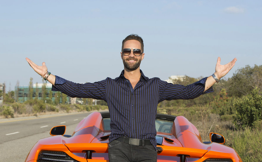 Three Commas Club member Russ Hanneman from Silicon Valley stands in front of his sports car.